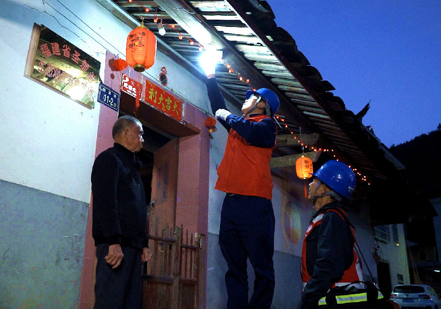 国网安溪县供电公司网格员李振森、陈焕东为龙涓乡新岭村返乡用户更换灯泡。(孙巧燕 摄) 国网安溪县供电公司网格员李振森、陈焕东为龙涓乡新岭村返乡用户更换灯泡。(孙巧燕 摄)