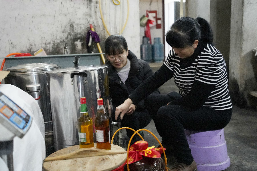 国网上杭县供电公司驻五龙村第一书记黄慧敏(左)向村里的酿酒大户了解米酒品质 (刘伟玲 摄) 国网上杭县供电公司驻五龙村第一书记黄慧敏(左)向村里的酿酒大户了解米酒品质 (刘伟玲 摄)