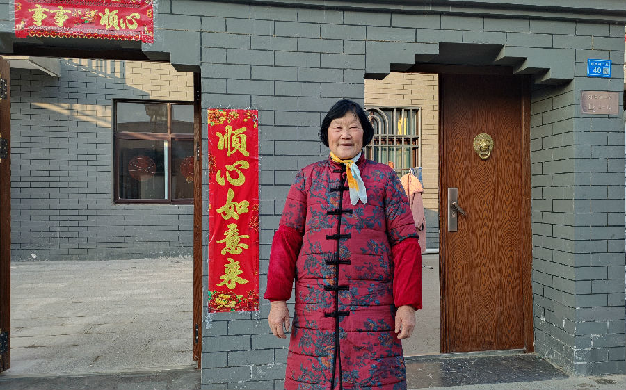 葛秀英站在新房子门口（张伟伟 摄）