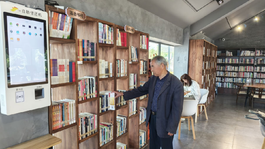 陆琪介绍沈家弄村文化礼堂书屋藏书情况（曾庆华 摄）