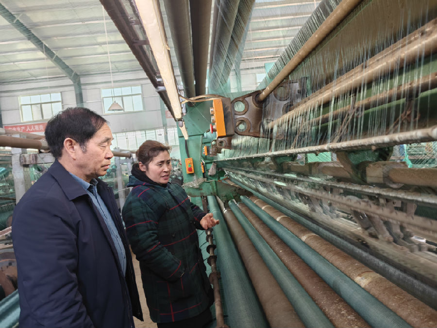 夏运峰（左一）在公司生产车间观察全自动数字化经编机运行情况（乔连军 摄）