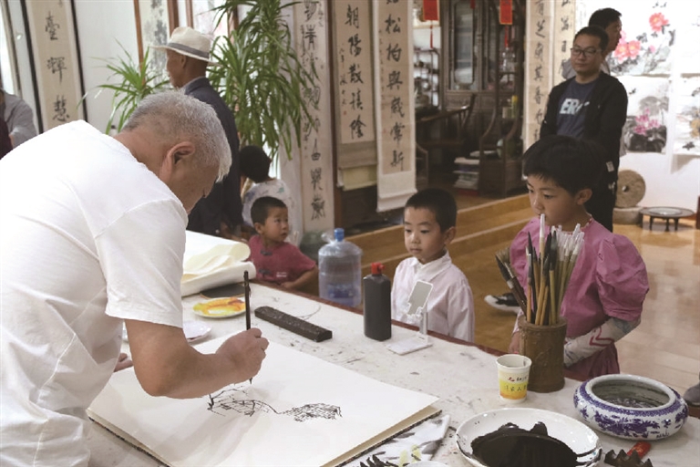 通渭县书画家现场作画，让小朋友直观感受艺术创作的魅力。     通讯员 张 赛摄