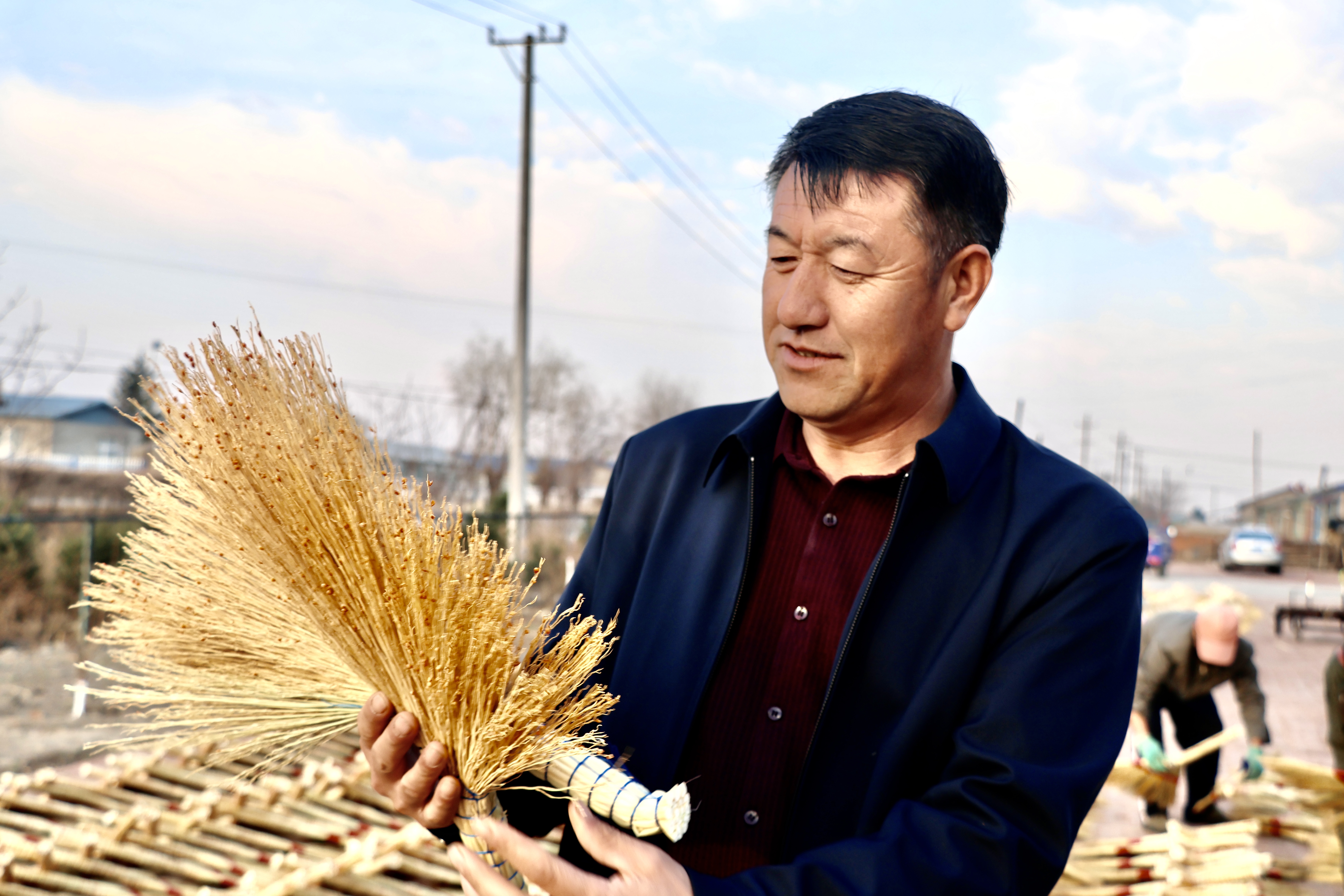 吕兰双在查看笤帚质量（高伟 摄）