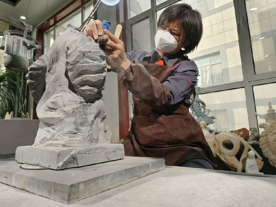 中国工艺美术大师、雕刻技艺非遗传承人高英坡在雕刻作品（唐笛 摄）