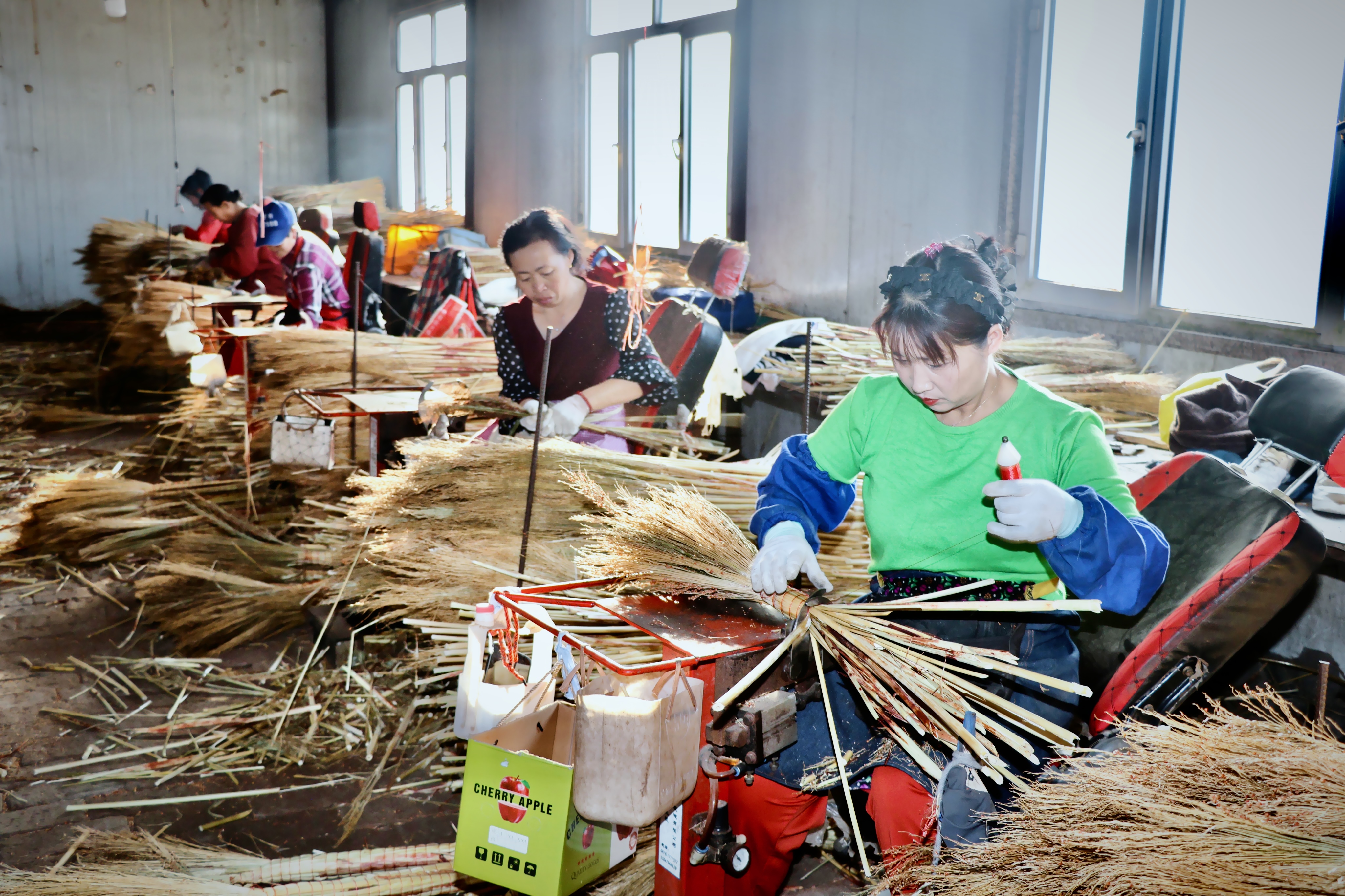 加工车间内，工人们在制作笤帚。（高伟 摄）