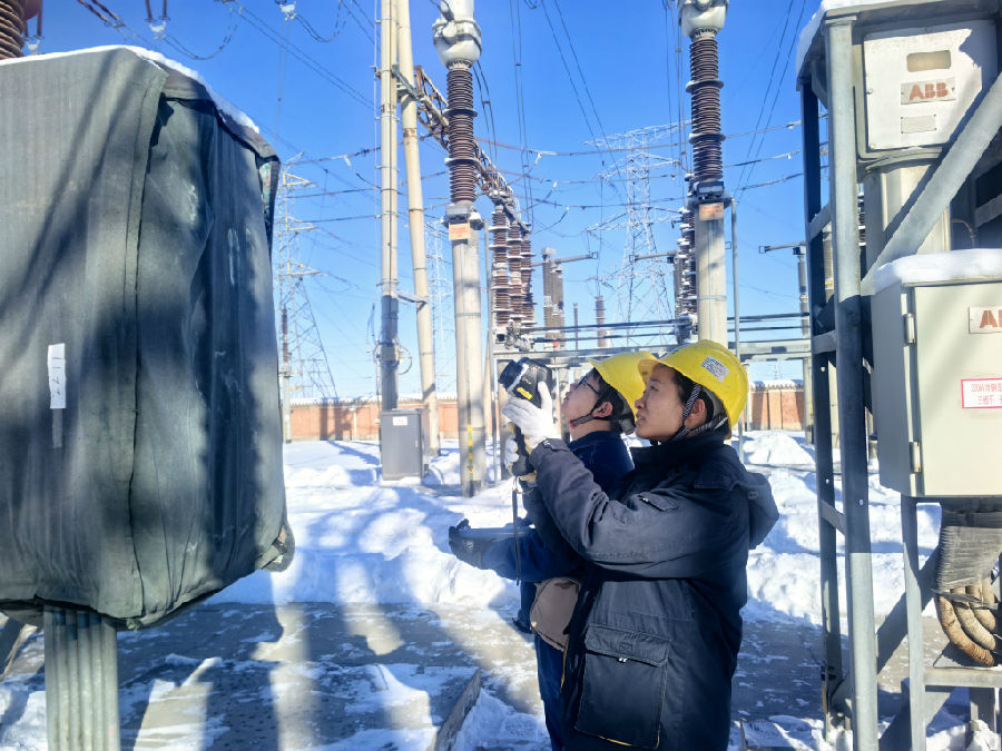 1月25日,员秋霞和变电运维值班员黄旗俊对瑶池变电站开关设备进行测温。(查燕荣 摄) 1月25日,员秋霞和变电运维值班员黄旗俊对瑶池变电站开关设备进行测温。(查燕荣 摄)