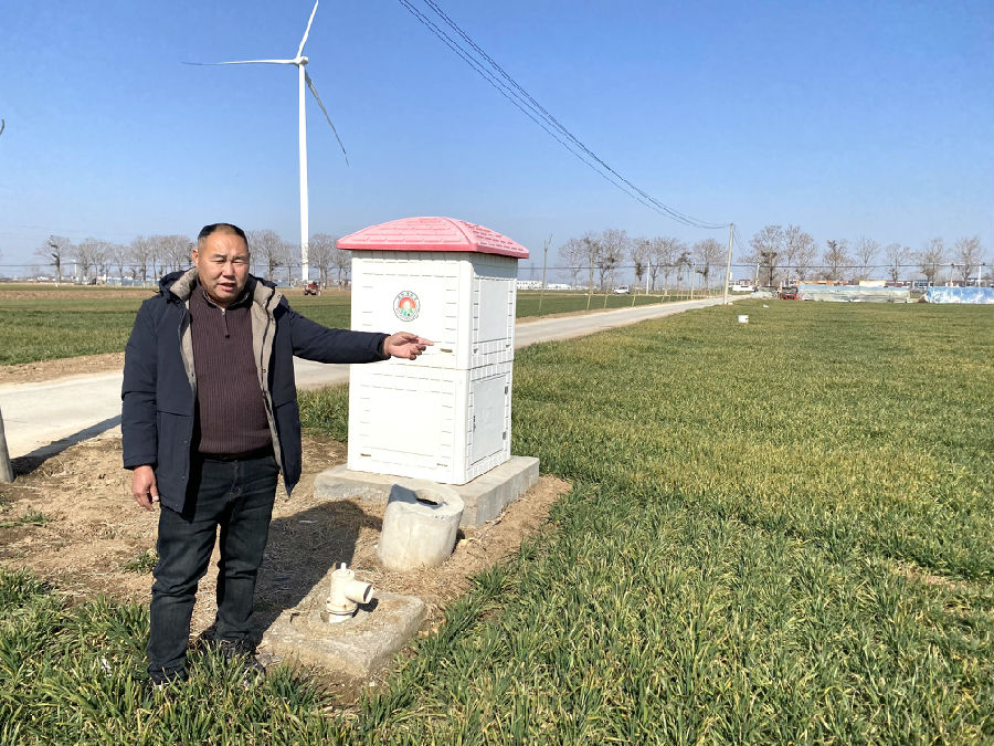 平店乡程岗村党支部书记、种粮大户程文喜介绍高标准农田设施及麦田长势。（赵永昌 摄）