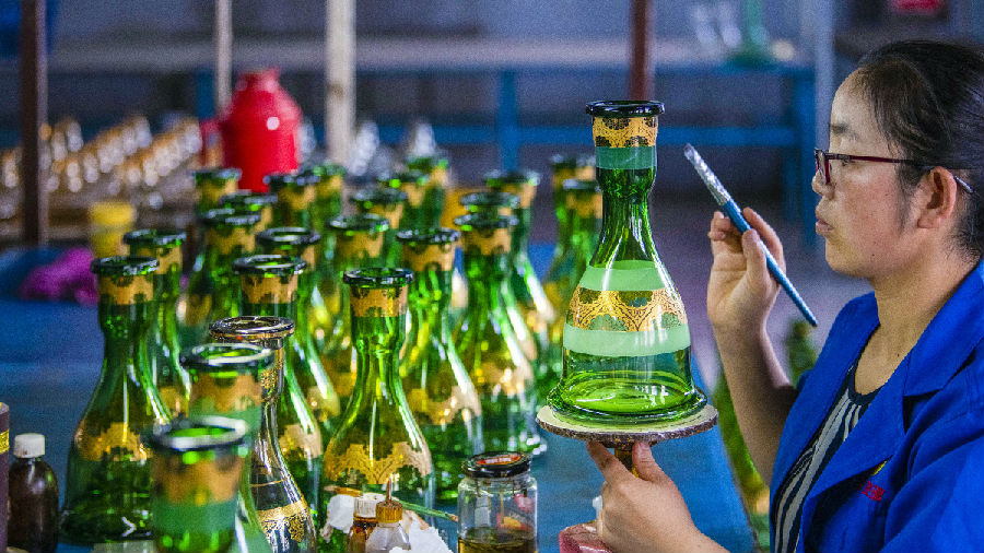 工人正在完成玻璃器皿的手绘流程 （吴遵民   摄）