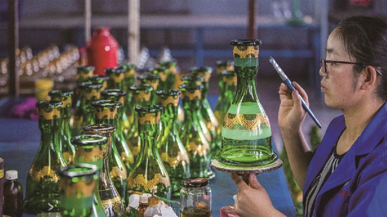     工人正在完成玻璃器皿的手绘流程 通讯员 吴遵民摄