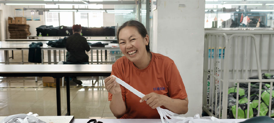 悬崖村村民吉足什作在凉山州恒驰服饰有限公司上班。（戚原 摄）