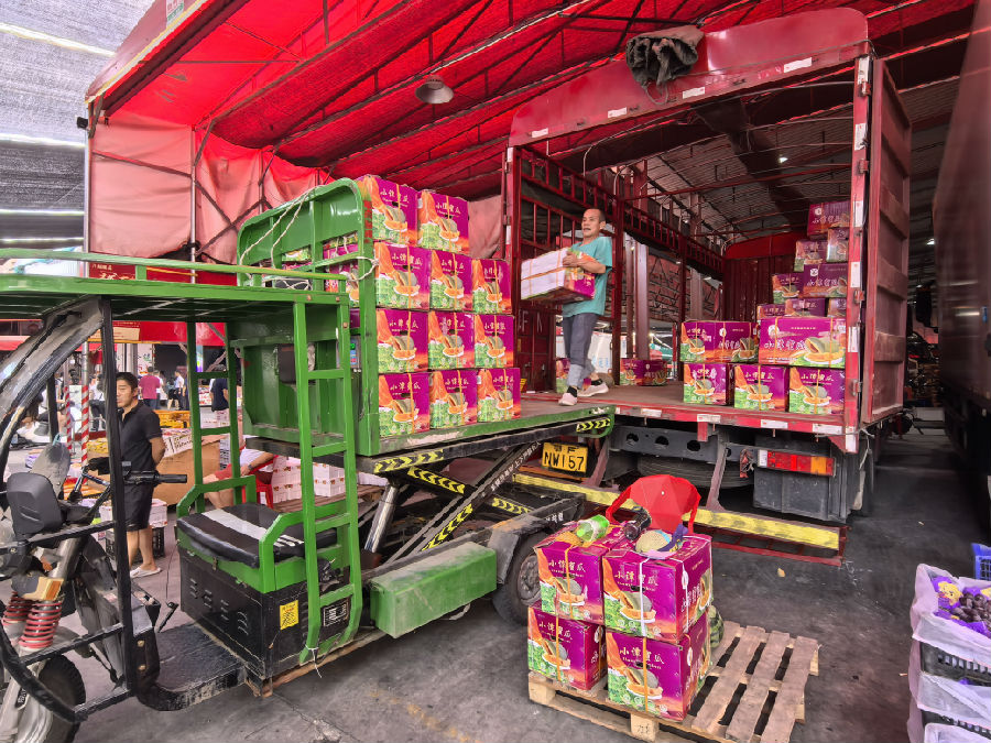 在精品水果区，商户们正忙着搬运水果。（余惠玲 摄）