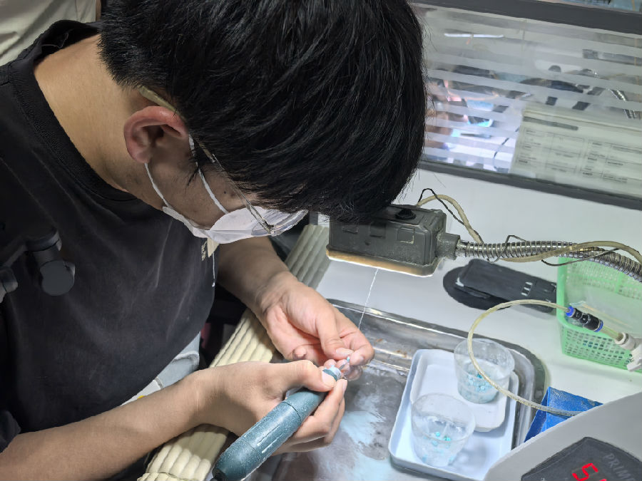 雕刻师正在打磨绿松石（余惠玲 摄）